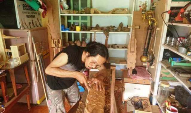 Muhamad F. Difinubun, akrab disapa Atyho, mengerjakan alat musik tradisional di bengkelnya di Desa Fiditan, Kecamatan Dullah Utara, Kota Tual, Sabtu (27/2/2021). Foto: Petter Letsoin