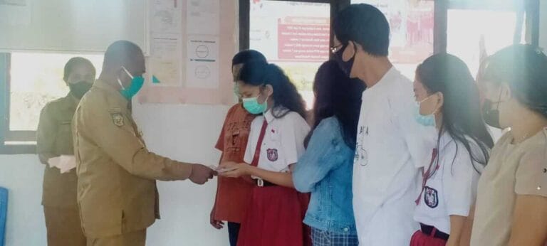 Kepala SD Naskat Mathias III Langgur A Saverius Rahabav menyerahkan sertifikat kepada Charisa Gloria Lefmanut, lulusan terbaik tahun ini. Selasa (15/6/2021). Foto: Labes Remetwa