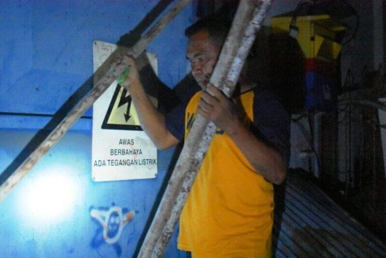 Tampak seseorang membuka sasi di lahan gardu PLN yang berlokasi di Kiom, Kota Tual, Sabtu (28/8/2021), setelah Wakil Wali Kota danTNI-Polri bernegosiasi dengan pemilik lahan. Foto: Labes Remetwa