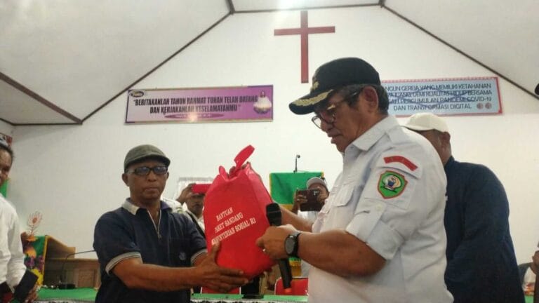 Bupati Malra M. Thaher Hanubun menyerahkan bantuan sosial secara simbolis, di Gereja Bethania Jemaat GPM Wab Ngufar, Rabu (27/7/2022). Foto: Labes Remetwa