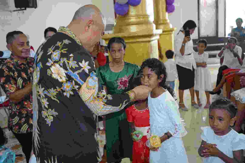 Selamat HUT ke-90 GPM: Semakin Bertumbuh Dalam Persaudaraan Sejati Melalui Rahmat Tuhan 1 Bupati Timo saat memberikan kue ke anak-anak.